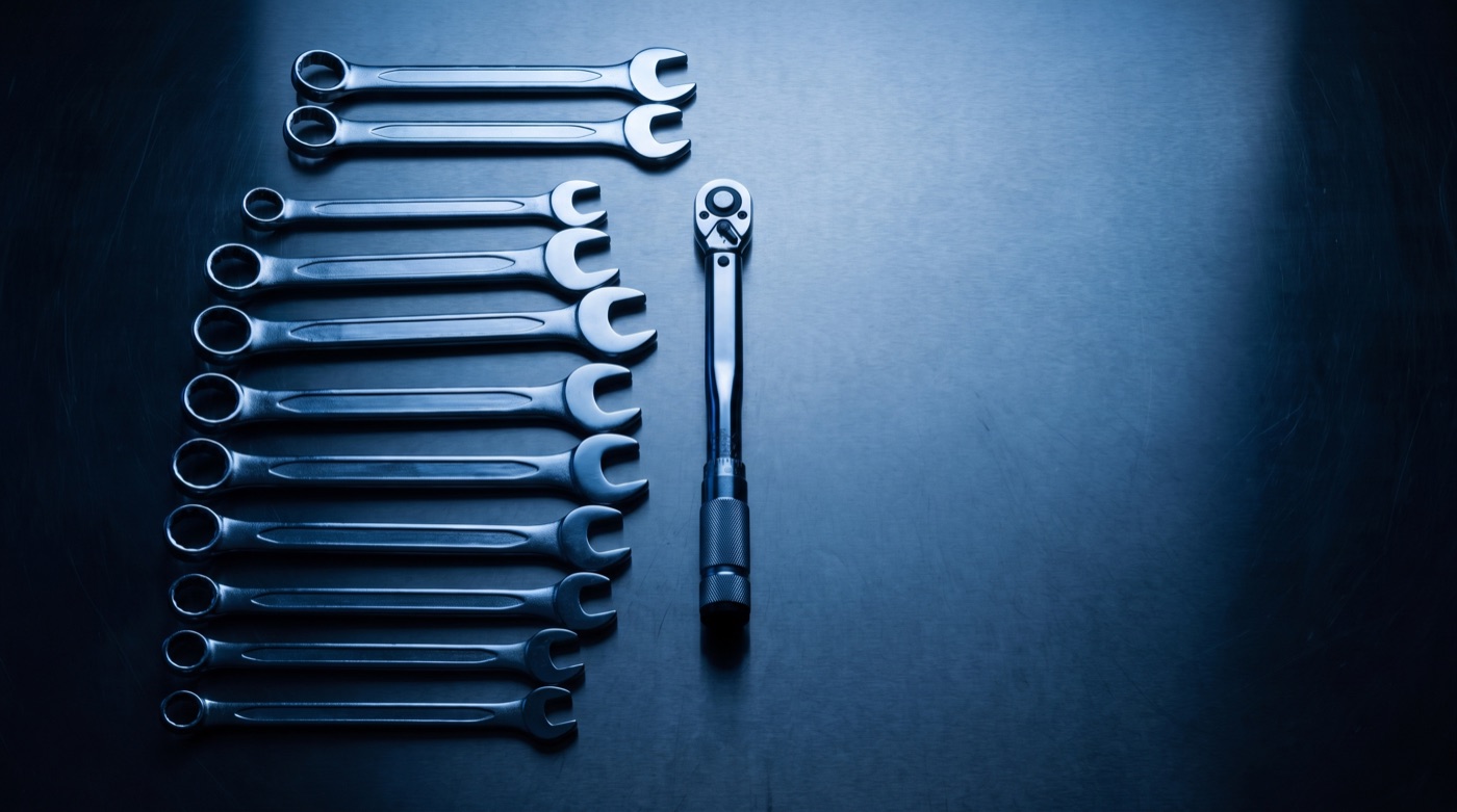 Mechanic hand tools laid out on a steel bench
